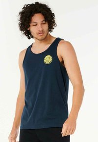 Marineblå tanktop lavet af blød stof med et rundt gult logo på venstre brystområde, der fremhæver en afslappet pasform og ærmeløst design.
