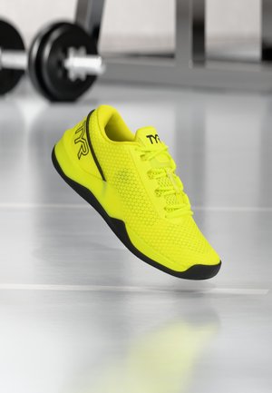 Neon-gelbe Sportschuhe mit Netzstruktur, schwarzen Akzenten und einer gepolsterten Zunge. Sie haben eine geschwungene Form und ein Schnürdesign.