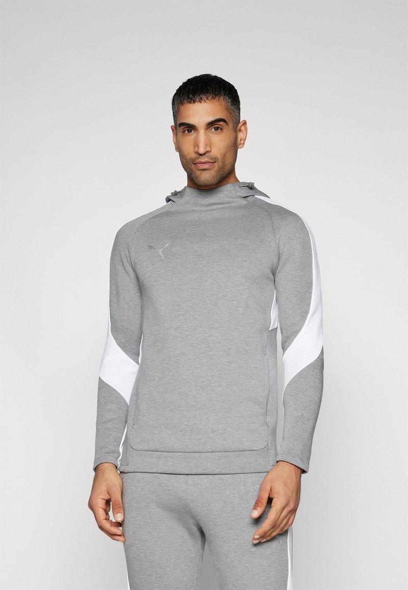 Grå sports sweatshirt med høj krave, hvide sideaccenter og hætte, lavet af et glat og strækbart stof. Har en forlommer.