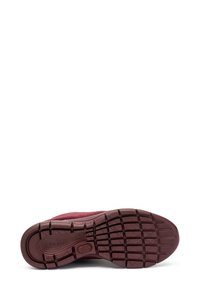 Zapatilla burdeos con suela de goma texturizada, que presenta un diseño de banda para mejorar la tracción. Parte superior de tela suave con detalles mínimos.