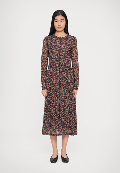 Vestido negro de flores con mangas largas y cuello redondo, que presenta un patrón de flores rojas y verdes, hecho de una tela transparente.