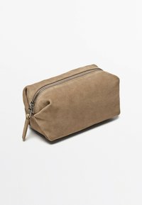 Borsa cosmetica in suede color marrone chiaro, di forma rettangolare con una chiusura a zip nella parte superiore, caratterizzata da una texture morbida e un design minimalista.
