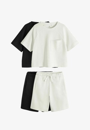 Dve neformálne súpravy s tričkami s krátkym rukávom a šortkami; jedna súprava biela s predným vreckom, druhá čierna, vrstvená za ňou.