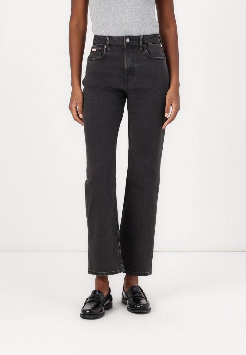 Svarte høytaljede jeans med rett ben-design, som har frontlommer, knappelukking og subtile sømdetaljer.