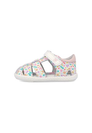 Sandalia blanca para niño pequeño con patrones multicolores de estrella, corazón, corona y peine, correa de velcro y suela blanca perforada.