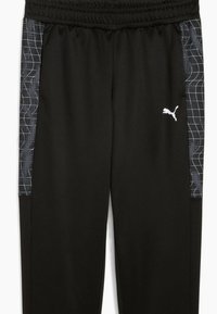Svarta sportbyxor med elastisk midja, med svarta och grå mönstrade sidopaneler och en vit logotyp på den nedre fronten.