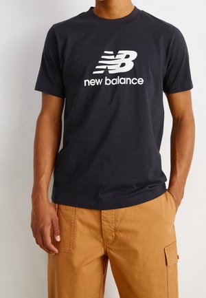 Czarna bawełniana koszulka z krótkim rękawem z białym logo "New Balance" na środku. Klasyczny dekolt typu crew neck.