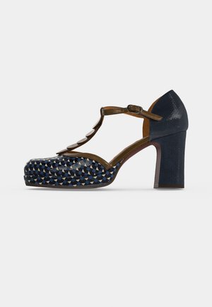Vue de profil d’un escarpin à plateforme à motifs bleu marine et bleus, avec une bride en T marron, une boucle et un talon haut épais.