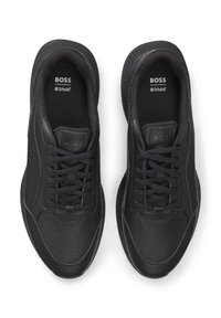 Mustat urheilukengät, joissa sileä nahkamainen päällinen, verkkopaneelit ja rei'itetty kuosi. Kenkien pohjat ovat kuvioidut ja niissä on nauhallinen kiinnitys.