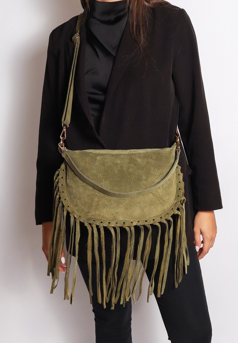 Borsa a spalla in suede verde oliva con frange, forma rotonda, tracolla in pelle e cuciture decorative lungo il bordo superiore e i lati.