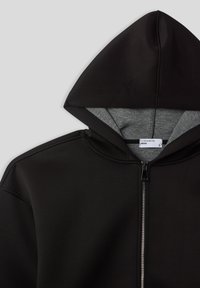 Felpa nera con zip e rivestimento interno grigio, con cappuccio, caratterizzata da un'etichetta "Terranova Man" all'altezza del collo.