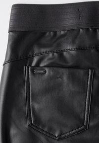 Svarta fusk läderbyxor med bred elastisk midja, en bakficka med en liten logotags och en slät yta.