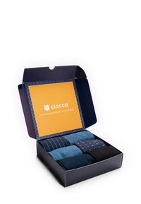 Set in scatola di quattro paia di calze in diverse tonalità di blu e nero, con motivi di righe e pois, presentate in una scatola blu navy.