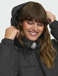 Černá vypolstrovaná bunda s kapucí, která má přední zip a elastické manžety. Hladká textura a prošívaný design s viditelnými švy.