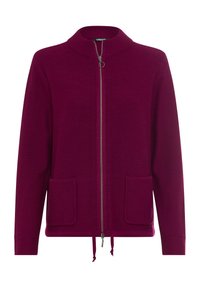 Cardigan in deep burgundy, knitted texture, front zipper closure, two patch pockets, and drawstring hem. Minimalist design with a high collar.