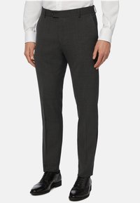 Temno sivi hlače iz teksturirane tkanine, s slim fit krojem, ravnim sprednjim delom in stranskimi žepi. V kombinaciji z črnimi poslovnimi čevlji.