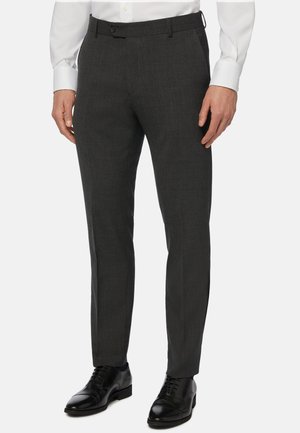 Dunkelgraue Hose aus strukturiertem Stoff, mit schlanker Passform, flachem Bund und seitlichen Taschen. Kombiniert mit schwarzen Dressschuhen.