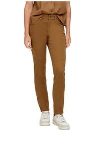 Pantalon slim-fit marron en tissu mélangé coton, avec fermeture à bouton et deux poches avant, associé à des baskets blanches.