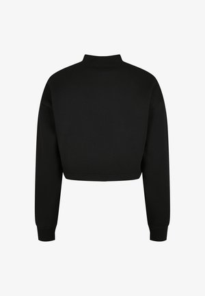 Svart cropped genser med høy krage, lange ermer og ribbestrikkede mansjetter. Laget av et glatt, mykt materiale med et rent, minimalistisk design.