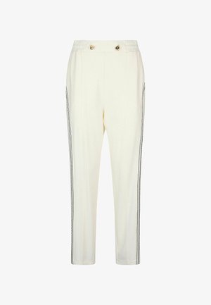 Kremowe spodnie o luźnym kroju, z elastycznym pasem, dwoma ozdobnymi guzikami i czarnymi paskami po bokach dla kontrastu.
