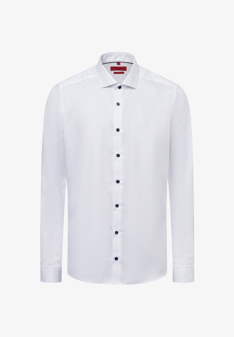 Weißes langärmliges Hemd aus strukturiertem Stoff, mit klassischem Kragen und dunkelblauen Knöpfen, die vorne entlang laufen. Rotes Etikett im Kragen.