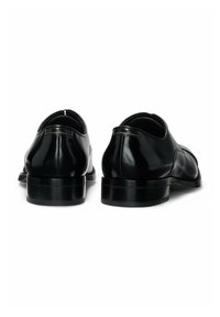Black leather dress shoes with a polished finish, rounded toe, and low stacked heel; features subtle stitching and a smooth texture.