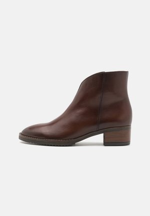 Brune lær ankle boot med rund tå, minimal design, elastisk sidepanel og stabelhælt. Tekstureret sål for bedre greb.
