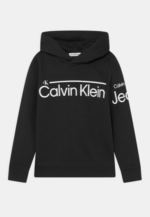 Sort Calvin Klein hættetrøje med hvidt logotekst på brystet og delvist på venstre ærme, med hætte og lange ærmer.