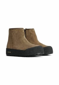 Ruske nubuk ankle sa teksturiranom crnom gumenom đonu, s klasičnom siluetom i bočnim zip zatvaranjem za lakše oblačenje.