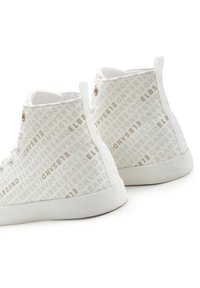 High-top sneakers in white fabric with a subtle tan logo pattern, featuring metal eyelets and a white rubber sole.