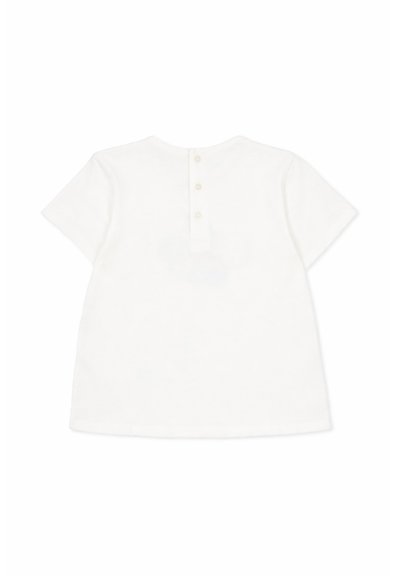 Camicia bianca a maniche corte con patta posteriore con tre piccoli bottoni, mostrata distesa su uno sfondo bianco.