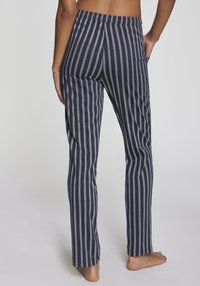 Randiga pyjamasbyxor i marinblått och grått, tillverkade av mjukt material, med resårmidja och sidfickor. Rakt ben-design.