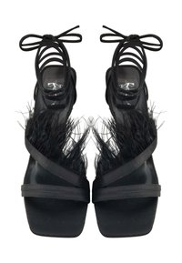 Schwarze High-Heel-Sandalen mit Knöchelriemen, die über Federakzente im Zehenbereich und eine glatte matte Oberfläche verfügen.