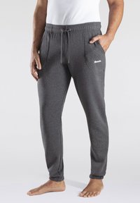 Gray fleece jogger pants with elastic waistband, drawstring, side pockets, and ribbed cuffs. White "Bench" logo on the left pocket.