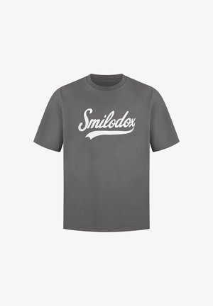 Szary T-shirt z krótkim rękawem z białym, kursywnym napisem "Smilodox" na klatce piersiowej na jednolitym tle.