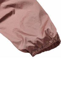 Lichtroze, gestructureerde stofmouw met een gegatherde elastische manchet. Het oppervlak heeft een subtiel geometrisch patroon en een gladde textuur.