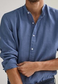 Blauw katoenen overhemd met knopen en een Mandarin kraag, met een zachte textuur en opgerolde mouwen, met subtiele stikdetails.