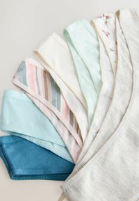 Hét összehajtott női fehérnemű pár különböző pasztellszínekben és mintákkal, legyező alakban elrendezve világos felületen.