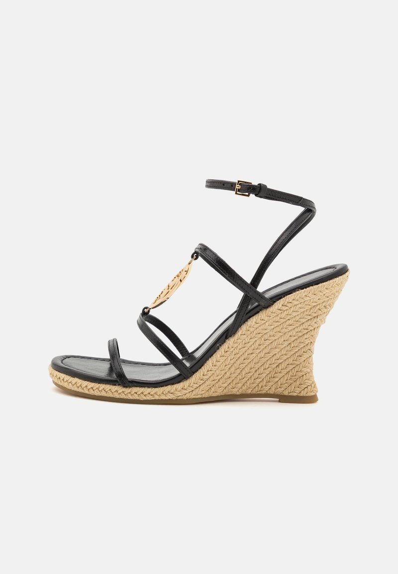 Sandale compensée en cuir noir à brides avec talon plateforme tressé beige et breloque décorative dorée sur la bride avant.