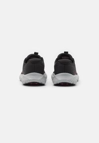 Scarpe da ginnastica nere con suole grigie, caratterizzate da una finitura testurizzata, tallone rinforzato e dettagli riflettenti. La vista da dietro mostra il logo e i dettagli del design.