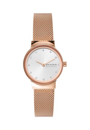 Rožnato zlata ura z mrežastim trakom, srebrnim številčnico, kristalnimi označevalci ur in rožnato zlati kazalci, ki kažejo 9:10, znamka Skagen Denmark.