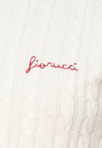Biały sweter z dzianiny z splotem w warkocze oraz czerwonym haftowanym napisem marki "fiorucci" z przodu.