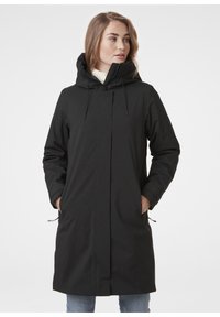 Černý kabát do délky ke kolenům s vysokým límcem, kapucí na stažení a bočními kapsami. Hladká, nepromokavá látka s minimalistickým designem.