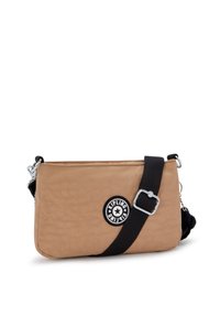 Borsa a tracolla rettangolare color sabbia con tracolla nera regolabile, hardware in argento, patch con logo Kipling e piccolo charm a forma di chiave nera sul lato.