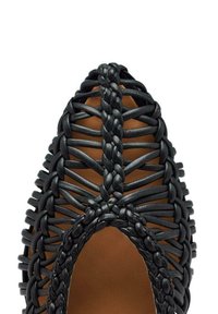 Zapato de cuero tejido negro con punta afilada, con un intrincado diseño trenzado y una sección abierta sobre el pie. Plantilla marrón suave visible.