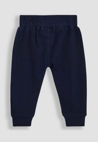 Tumed ribbed püksid elastse pahkluu labaga, kitsenevate varrukatega ja pehme tekstuuriga. Kujundatud mugavuse ja liikumisvabaduse jaoks.