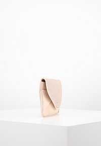 Růžová kabelka na ruku s klopou. Vyrobená z texturovaného materiálu, s hladkým dnem a zaoblenými okraji. Kompaktní, minimalistický tvar.