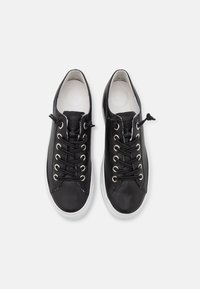 Black leather sneakers with white rubber sole, rounded toe, and black laces. Features silver eyelets, textured material, and minimalistic design.