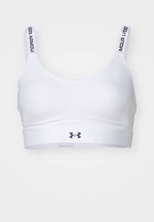 Sujetador deportivo blanco hecho de una tela suave, con una banda ancha y tirantes ajustables que llevan el texto "Under Armour". Logotipo centrado en la banda.