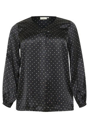 Černá saténová blůza s dlouhými balónovými rukávy, s výstřihem do V a vzorem s puntíky v světle béžové barvě. Přední detail se středním skladem.